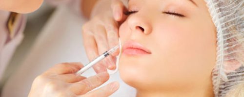 A woman receives an inejection on her face in the clinic.